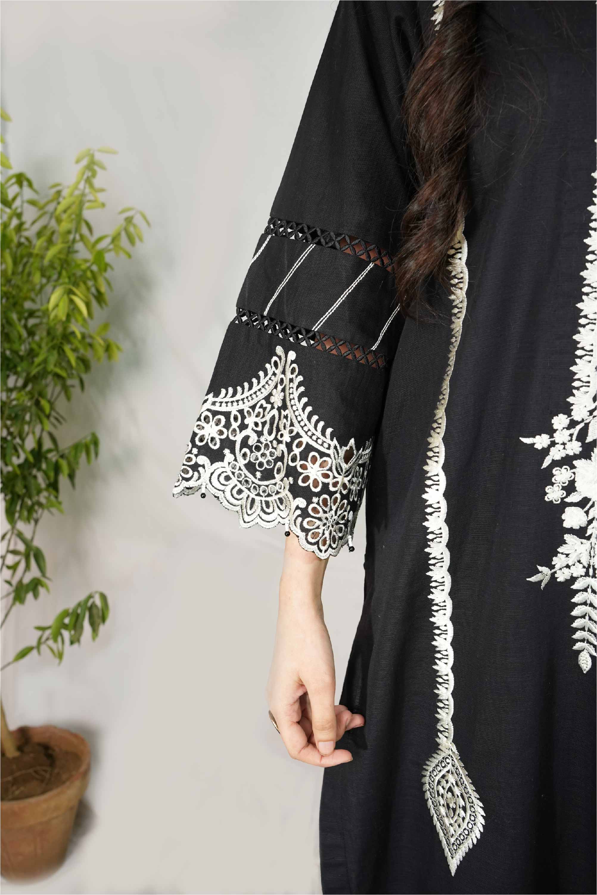 Black dress with white embroidery on a plain background