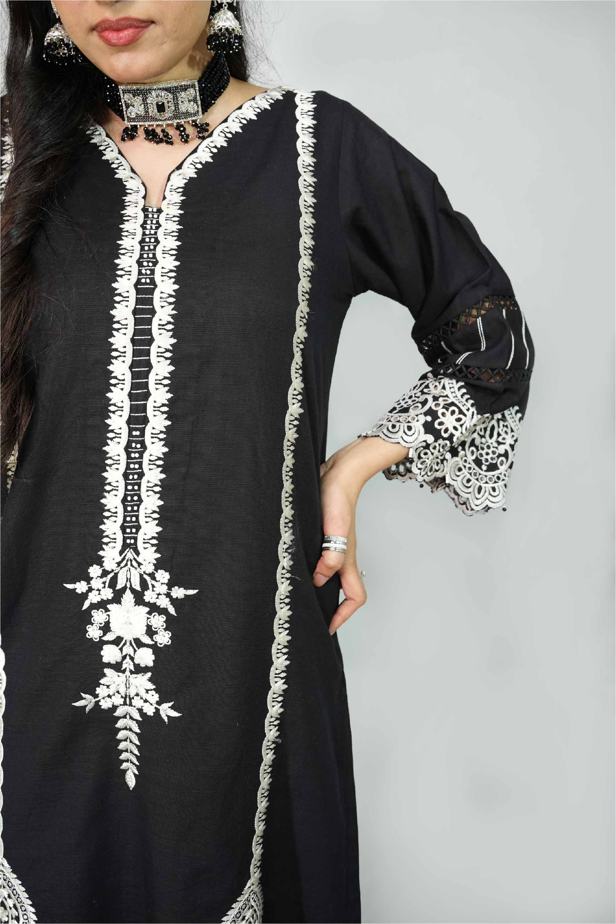 Black dress with white embroidery on a plain background