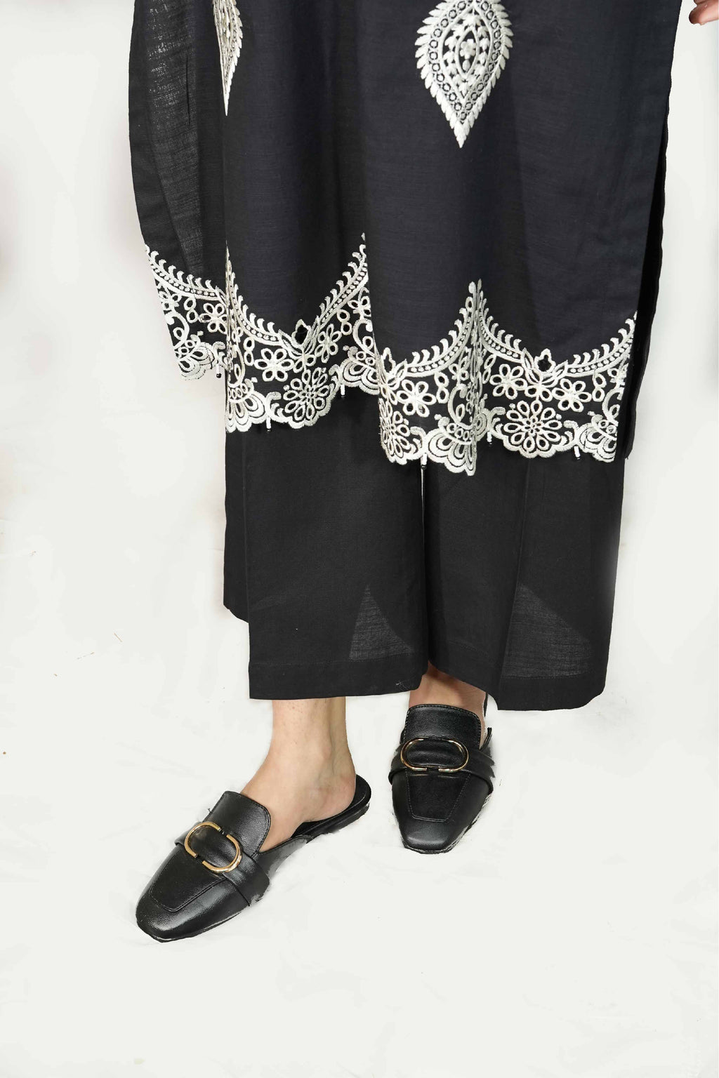 Black outfit with white lace details on a white background