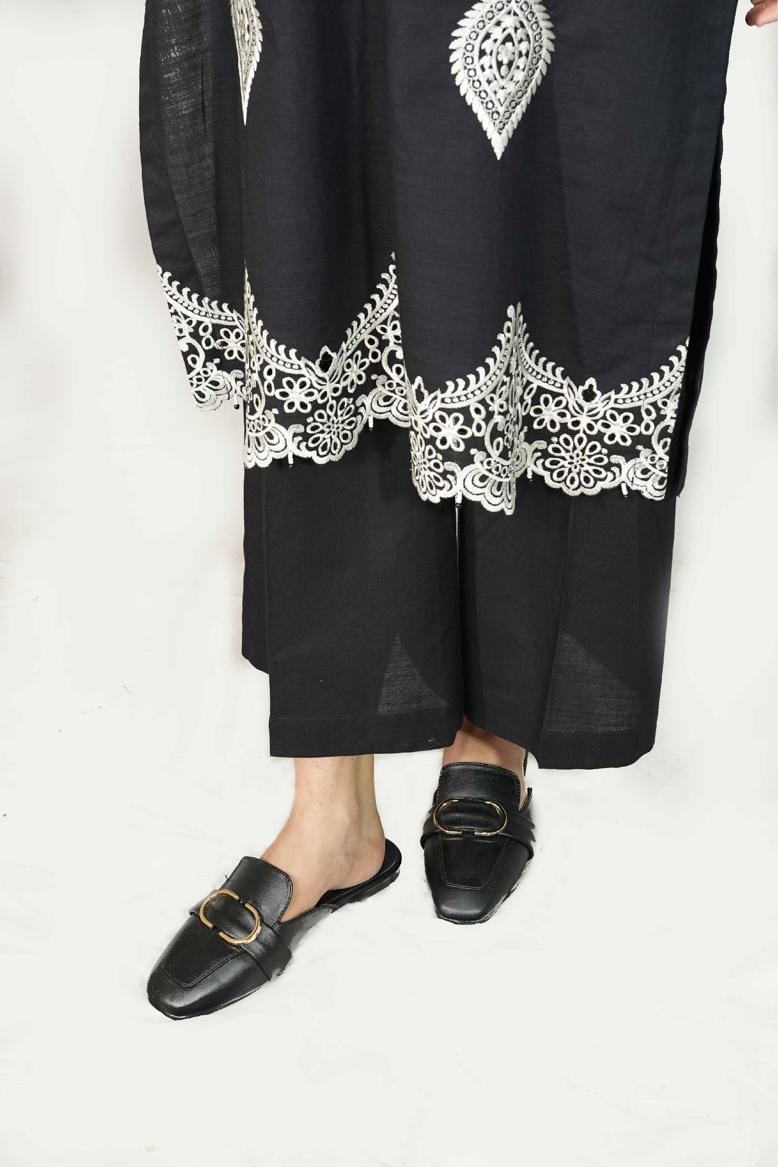 Black outfit with white lace details on a white background