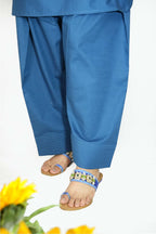 Blue pants worn by a person with sandals on a white background