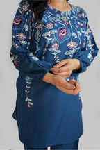 Blue embroidered outfit with floral patterns on a plain background