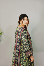 Woman wearing a traditional patterned outfit against a plain background