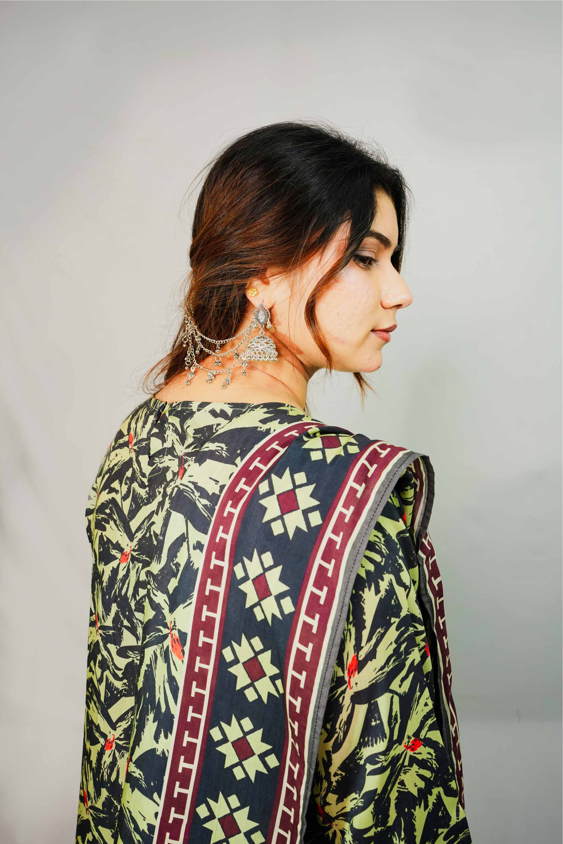 Woman wearing a patterned saree with a plain background