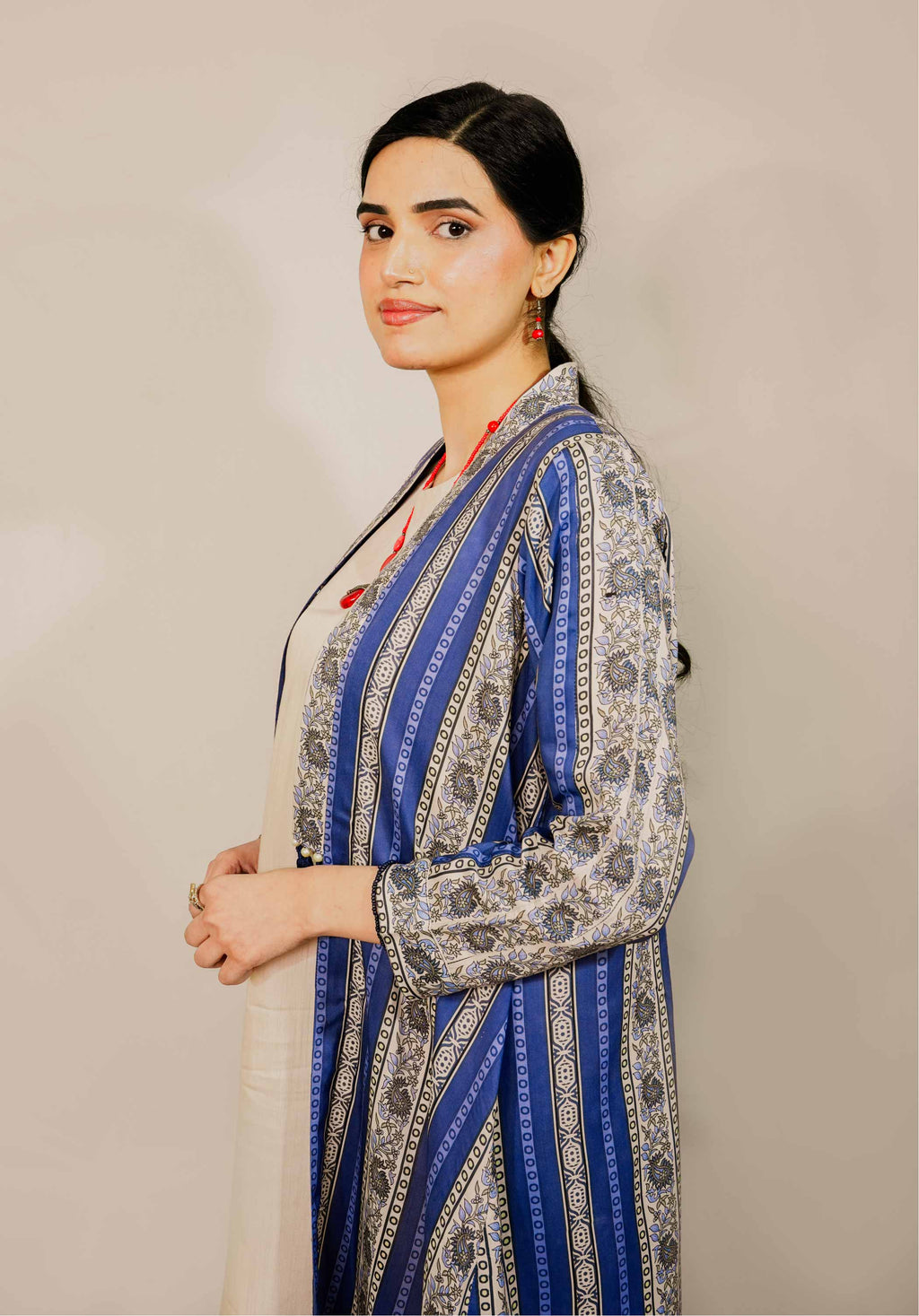 Woman wearing a blue and gray patterned dress against a beige background