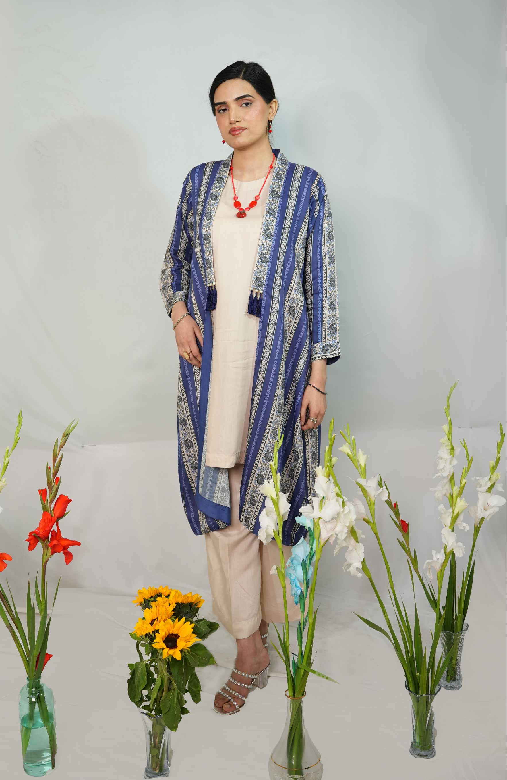 Woman wearing a blue and white patterned outfit with flowers in the foreground