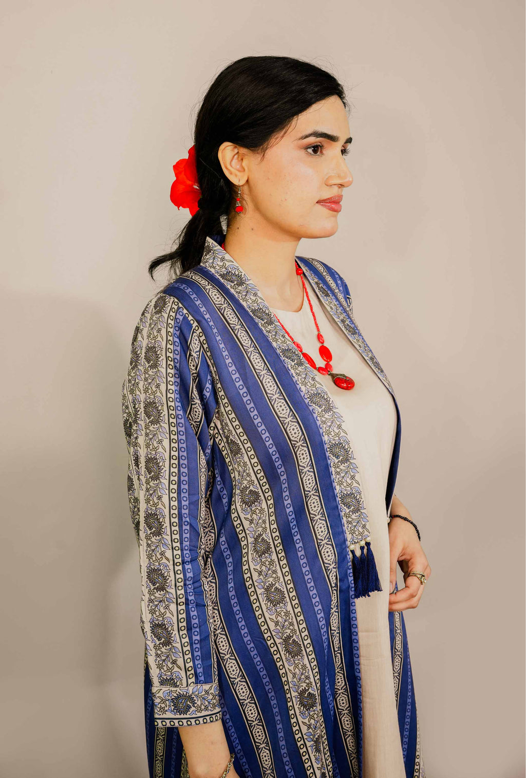 Woman wearing a blue and gray patterned outfit with a plain background