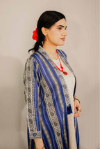 Woman wearing a blue and gray patterned outfit with a plain background