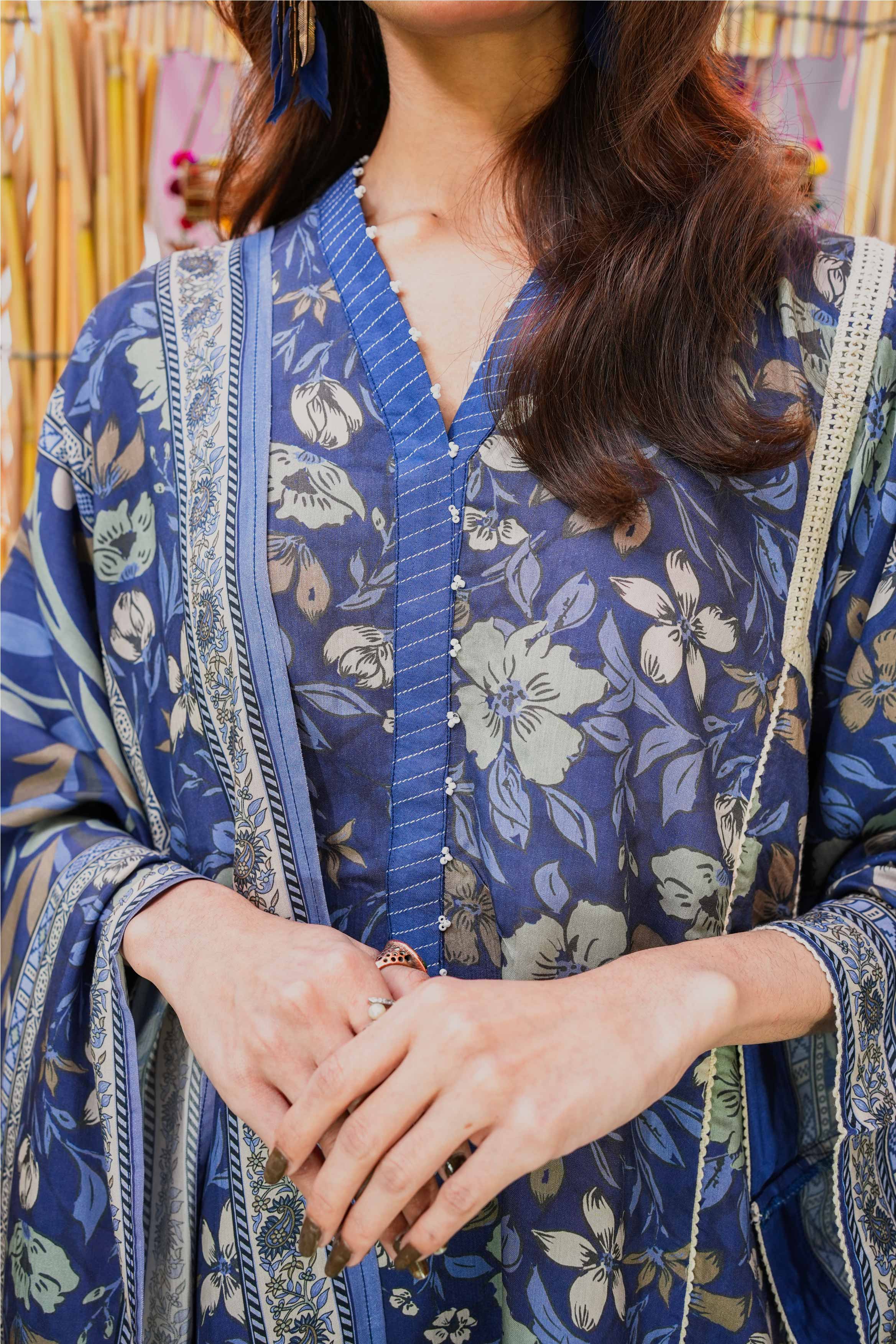 Person wearing a blue floral kimono-style garment with a blurred background