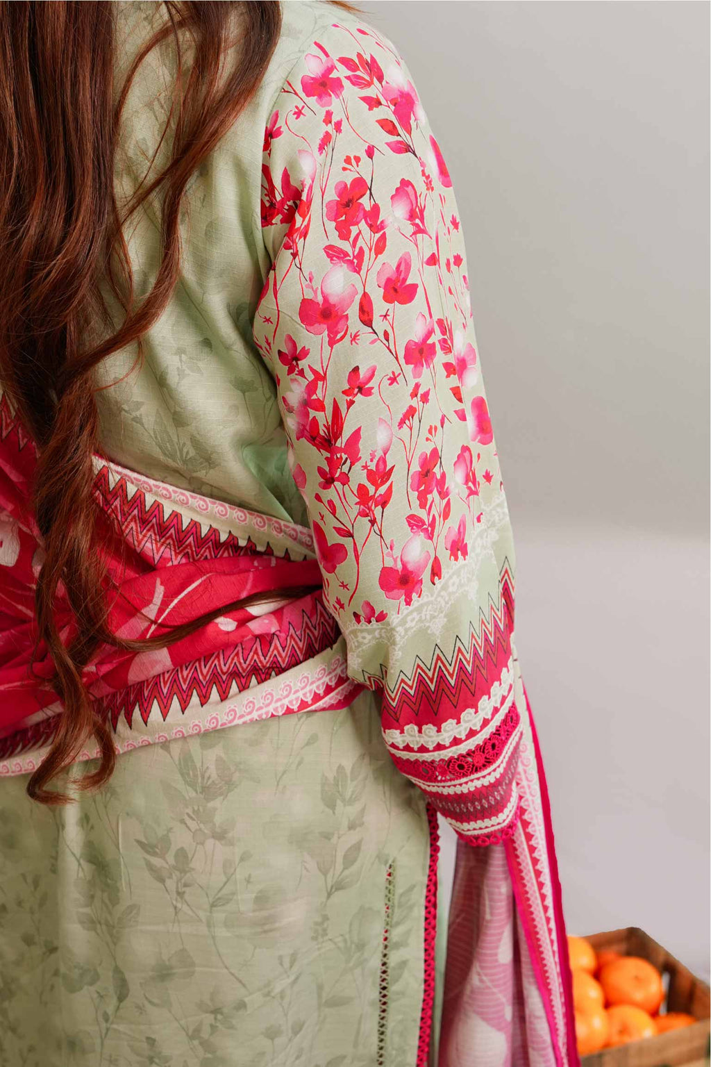 Traditional outfit with floral patterns and a red border on a plain background