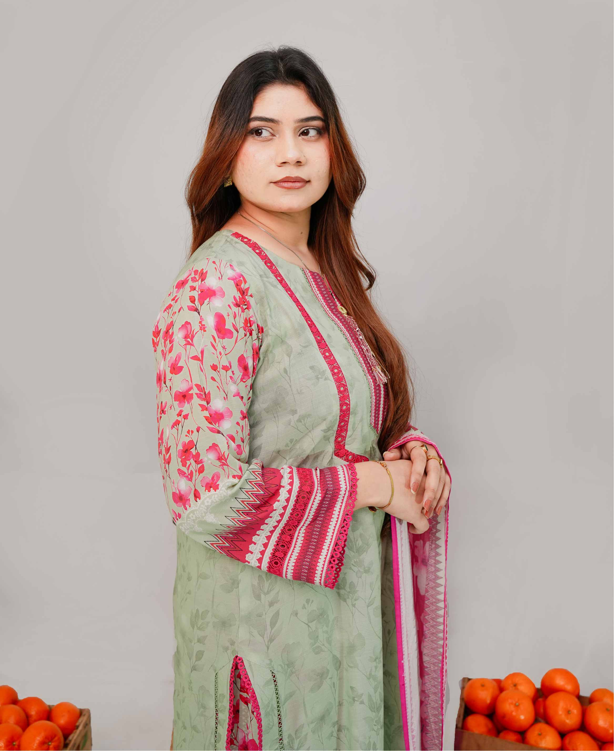 Woman wearing a green and pink traditional outfit with a plain background