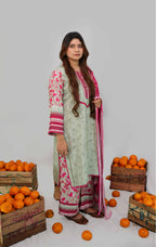Woman in a traditional outfit standing among crates of oranges on a plain background