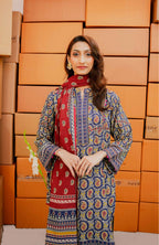Woman in a patterned outfit standing in front of stacked boxes