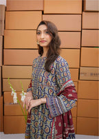 Woman in a patterned dress standing in front of stacked boxes