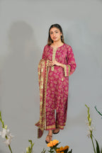 Woman wearing a pink traditional outfit with a floral pattern on a gray background