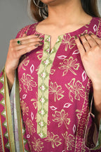 Woman wearing a pink kurta with floral patterns and green accents.