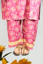 Person wearing pink floral pants with a gray background