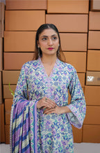 Woman in a patterned outfit standing in front of stacked boxes
