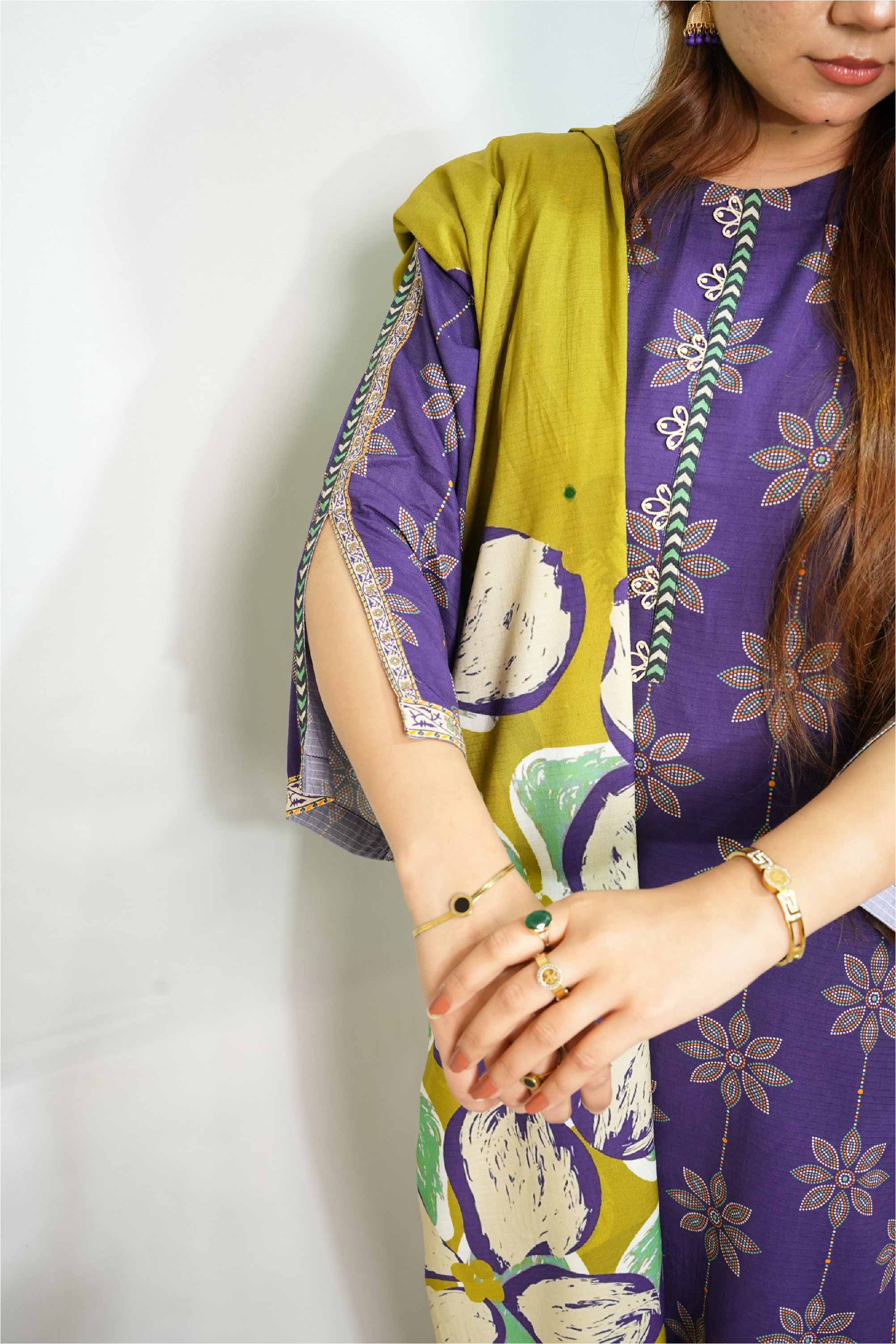 Person wearing a purple floral dress with a green jacket against a white background