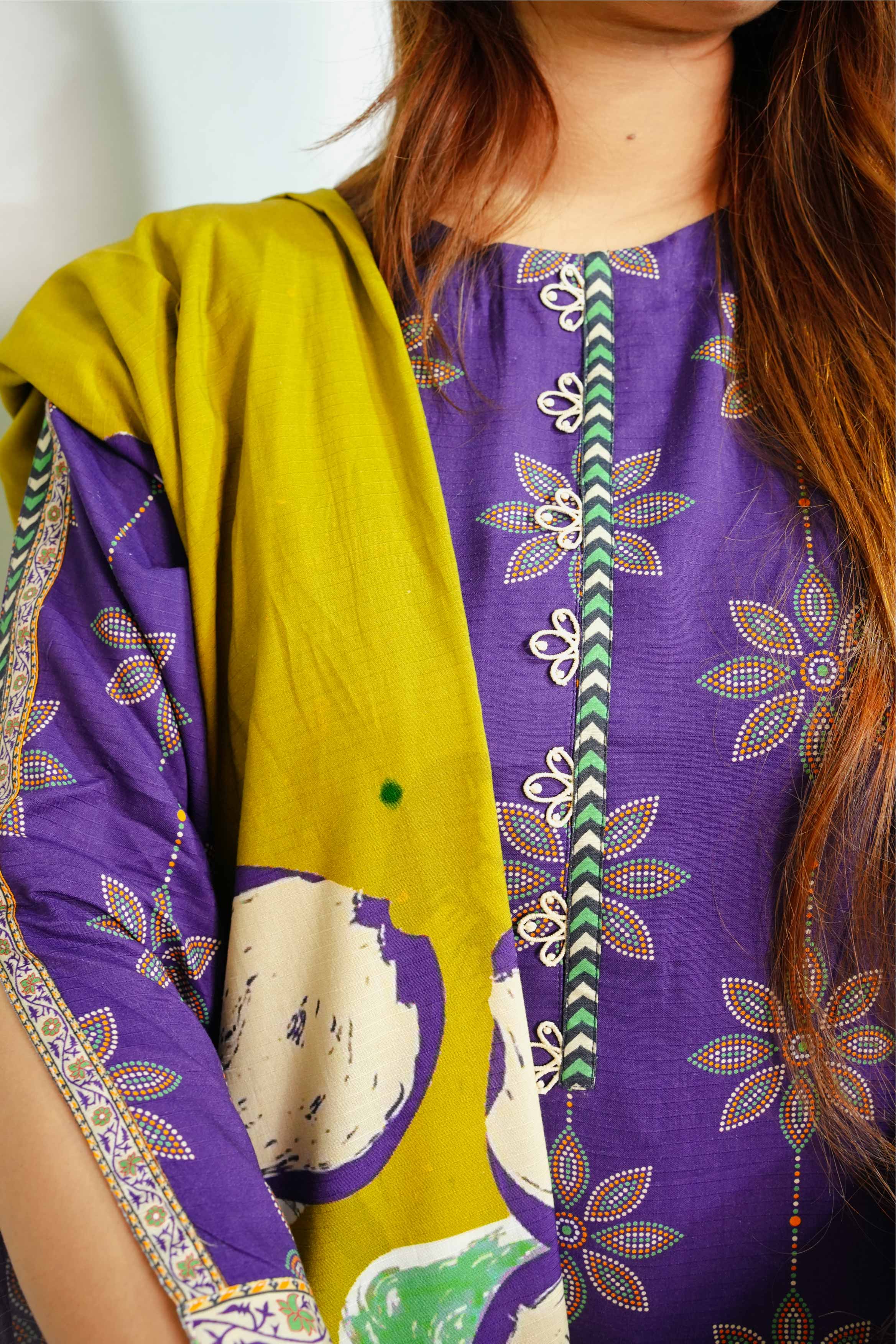 Person wearing a purple and yellow traditional outfit with floral patterns.