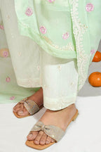 Light green dupatta with floral patterns draped over a person wearing white pants and sandals on a light background.